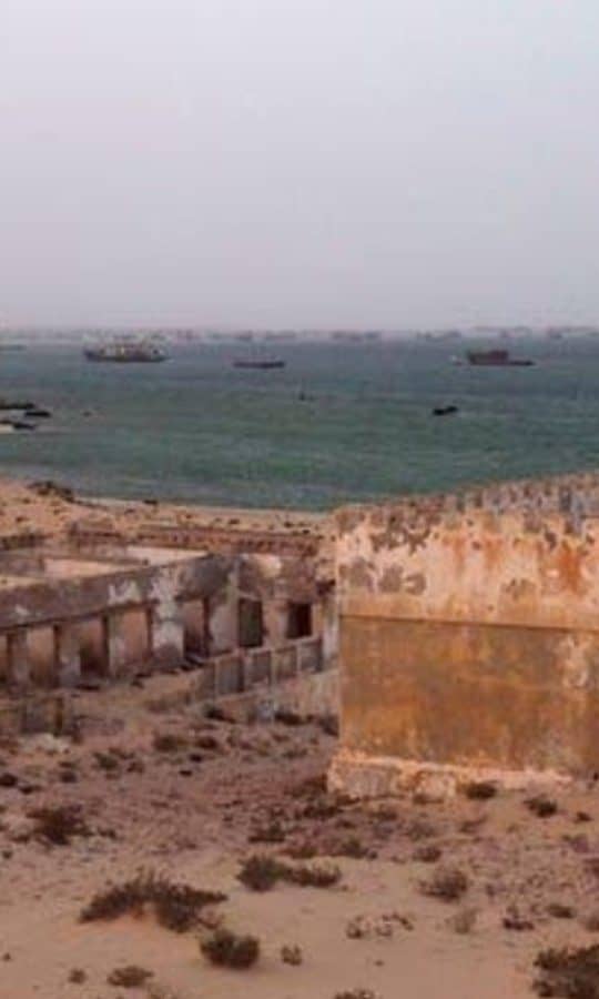 أطلال مباني الكويرة المهجورة على شبه جزيرة الرأس الأبيض، وفي الخلفية ميناء نواذيبو